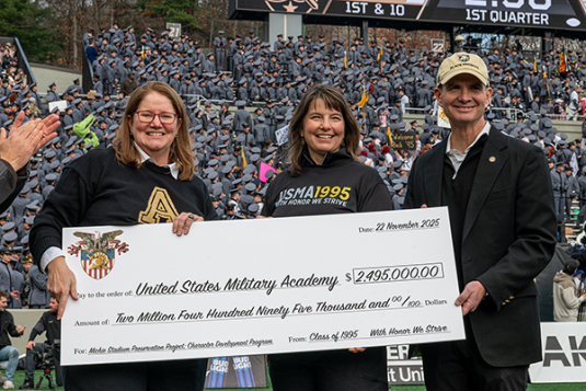 USMA graduates from the class of 1995 presenting a check at Saturday's football game